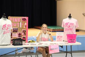 Student Working the Pink Out Information Table