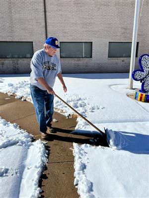 Custodian shoveling snow